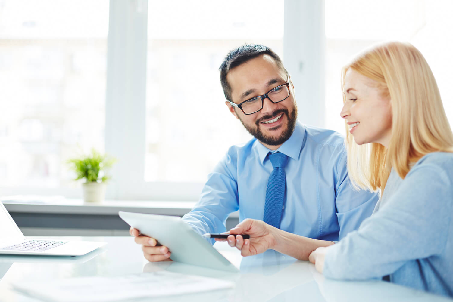 hombre y mujer riendo mirando tablet